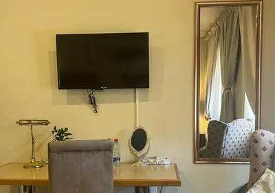 a room with a table with a television on the wall at The Lion Room at Frederick's Place in Pretoria