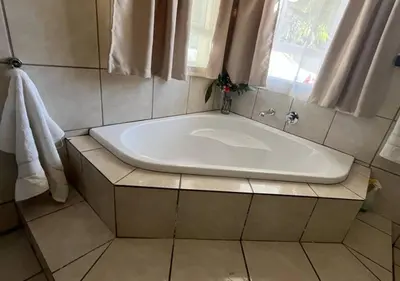 a large bath tub in a bathroom with a window at The Lion Room at Frederick's Place in Pretoria