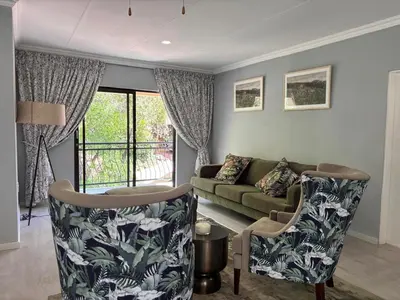 a living room with a couch and two chairs at Khenjadji at Fish Eagle Bay in Warmbaths