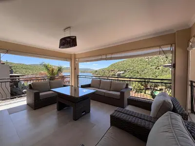 a living room with couches and a view of the ocean at Khenjadji at Fish Eagle Bay in Warmbaths