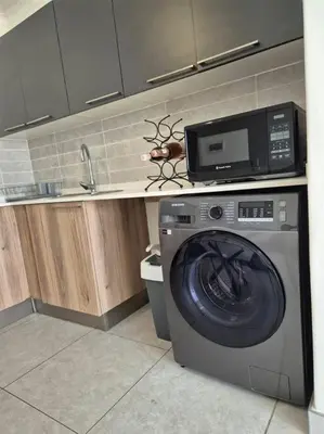 a kitchen with a washing machine and a microwave at Tetani's Luxury Oasis in Lakeside