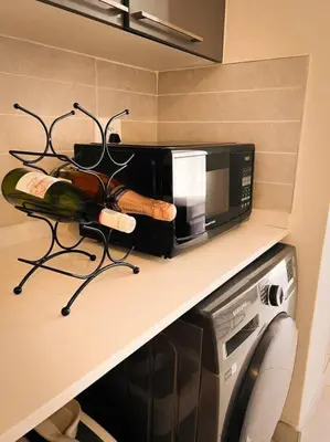 a kitchen counter with a microwave and a bottle of wine at Tetani's Luxury Oasis in Lakeside