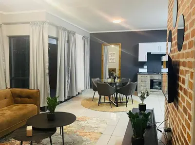 a living room with a couch and a table at Apparent Self Catering in Boschrand