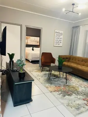 a living room with a couch and a table at Apparent Self Catering in Boschrand