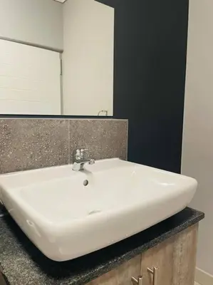 a white sink in a bathroom with a mirror at Apparent Self Catering in Boschrand