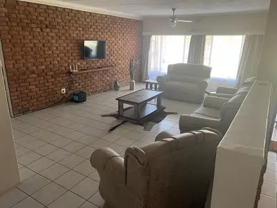 a living room with couches and a brick wall at Kremetart Villa in Alldays