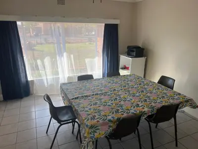 a dining room with a table and chairs and a window at Kremetart Villa in Alldays