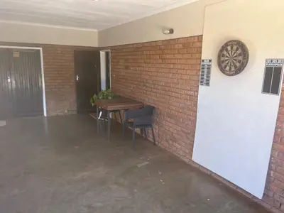 a room with a brick wall with a table and chairs at Kremetart Villa in Alldays