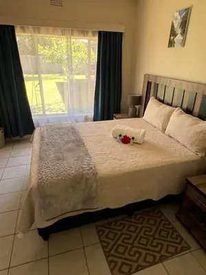 a bedroom with a large bed with flowers on it at Kremetart Villa in Alldays