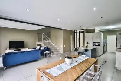 a living room with a blue couch and a table at Hartbeespoort Dam Getaway Home in Kosmos