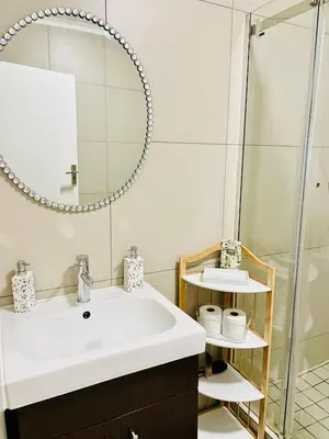 a bathroom with a sink and a mirror at The Classy West End 1 bed with sleeper couch in Midrand