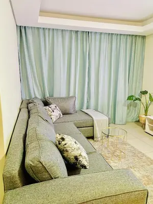 a living room with a couch with pillows on it at The Classy West End 1 bed with sleeper couch in Midrand