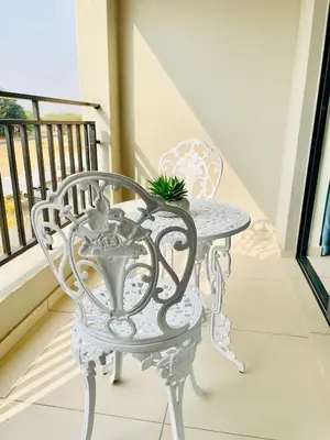 a white wrought iron table and chair on a balcony at The Classy West End 1 bed with sleeper couch in Midrand