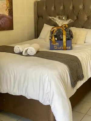 a bed with a gift box on top of it at Whizzy lifestyle lodge in Duvhapark
