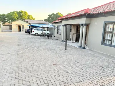 a brick parking lot in front of a house at Whizzy lifestyle lodge in Duvhapark