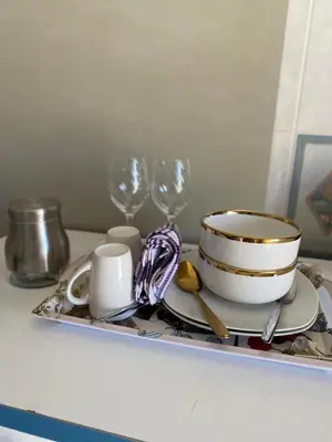 a plate with a bowl and two wine glasses on a tray at Whizzy lifestyle lodge in Duvhapark