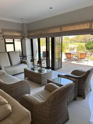 a living room with wicker chairs and a table at Pecanwood Holiday Home in Kosmos