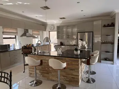 a kitchen with a counter with stools in it at Pecanwood Holiday Home in Kosmos