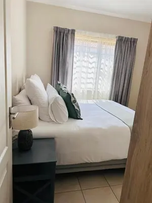 a bedroom with a bed with pillows and a window at 02 in Bel Aire place in Kempton Park