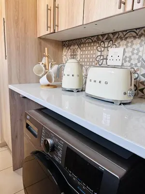 a kitchen counter with two toasters on top of a microwave at 02 in Bel Aire place in Kempton Park