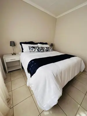 a bedroom with a large bed with a black and white blanket at 02 in Bel Aire place in Kempton Park