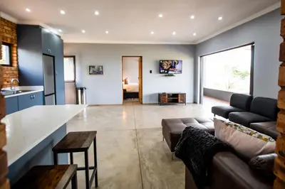 a large living room with a couch and a table at Sink Huis at Benlize in Pelindaba