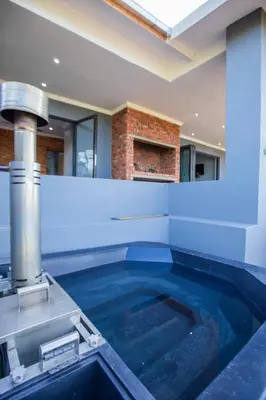a swimming pool in a house with a water fountain at Sink Huis at Benlize in Pelindaba