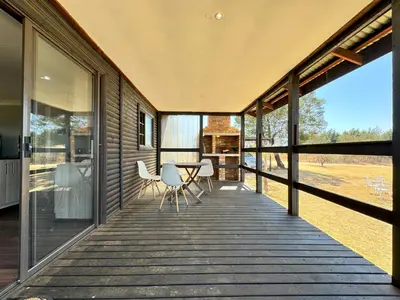 a wooden deck with a table and chairs on it at Kings 93 Cabins in Tierpoort