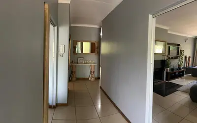 a hallway leading to a living room with a table at Escape At House 68 in Pretoria