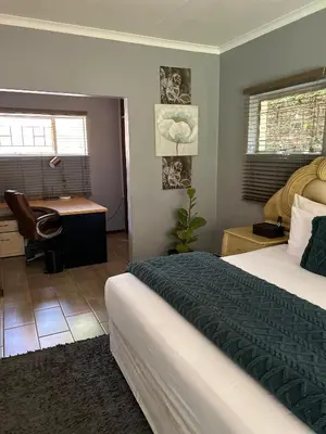 a bedroom with a bed and a desk in it at Escape At House 68 in Pretoria