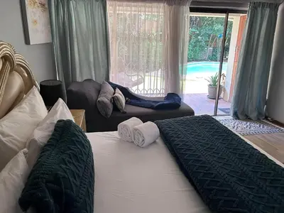 a bedroom with two beds and a view of a pool at Escape At House 68 in Pretoria