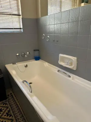 a white bath tub in a bathroom with a window at Escape At House 68 in Pretoria