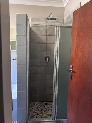 a shower with a glass door in a bathroom at Escape At House 68 in Pretoria