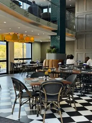 a restaurant with tables and chairs on a checkered floor at Acoustic Apartment in Pretoria