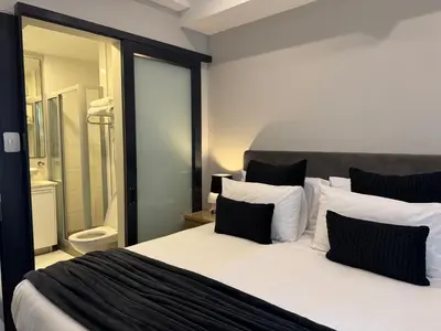a bedroom with a large white bed with black and white pillows at Acoustic Apartment in Pretoria
