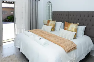 a large white bed with towels on top of it at Relmies Place in Modimolle