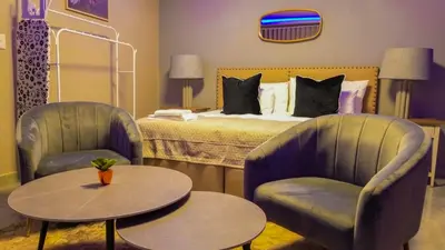 a hotel room with two chairs and a bed at Mercy Boutique Hotel in Thohoyandou