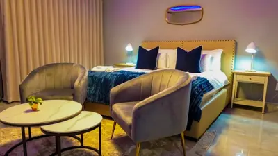 a hotel room with a bed and two chairs and tables at Mercy Boutique Hotel in Thohoyandou