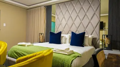 a bedroom with a large bed with blue pillows at Mercy Boutique Hotel in Thohoyandou