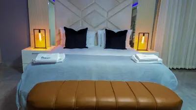 a large bed in a hotel room with two lamps at Mercy Boutique Hotel in Thohoyandou