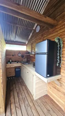 a kitchen with a refrigerator in a wooden cabin at Marepe Flora Bell mimosa in Kampersrus AH