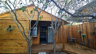 a log cabin with a patio and a fence at Marepe Flora Bell mimosa in Kampersrus AH
