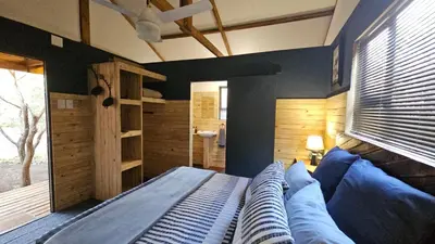 a bedroom with a bed with blue pillows at Marepe Flora Bell mimosa in Kampersrus AH