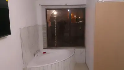 a white bath tub in a bathroom with a window at Thiwani Guest House in Kempton Park