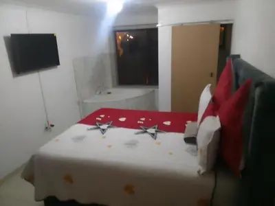 a bedroom with a bed with red and white pillows at Thiwani Guest House in Tembisa