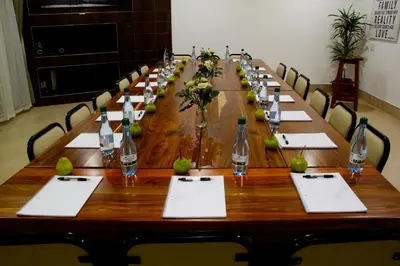 a long wooden table with chairs and bottles on it at Firwood Lodge in Pretoria