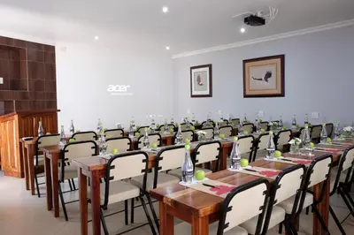 a conference room with long tables and chairs at Firwood Lodge in Pretoria