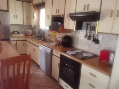 a kitchen with white cabinets and a stove top oven at Bosveld Kuier Woonstel in Bela-Bela