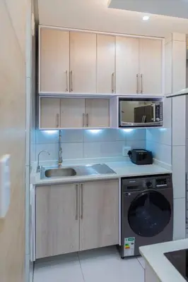 a kitchen with a sink and a washing machine at Hatfield on Park A in Pretoria