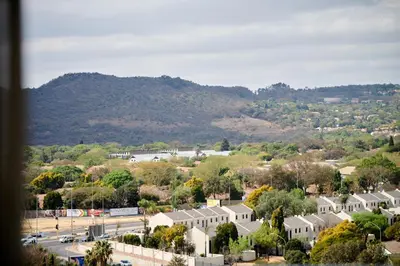 a town with houses and a mountain in the background at When Away - Your Home Away from Home in Pretoria